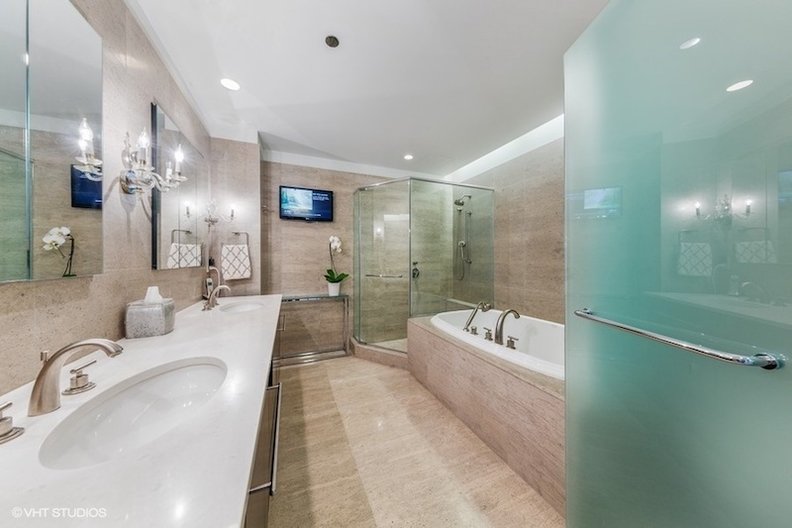Other than new lighter countertops and a television, the master bath is largely as the developers built it, in a neutral look that matches their later design of the rest of the condo.